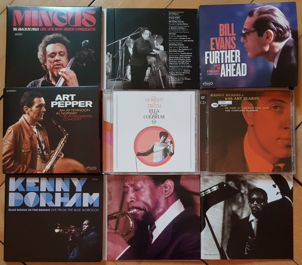 assembly of CDs on a wooden floor, from top right: "Mingus in Argentina", Bill Evans "Further Ahead", Art Pepper "An Afternoon in Kongsberg", Ella Fitzgerald "The Moment of Truth: Ella at the Coliseum", Kenny Burrell "On View at the Five Spot - Complete Masters", and Kenny Dorham "Blue Bossa in the Bronx" 
