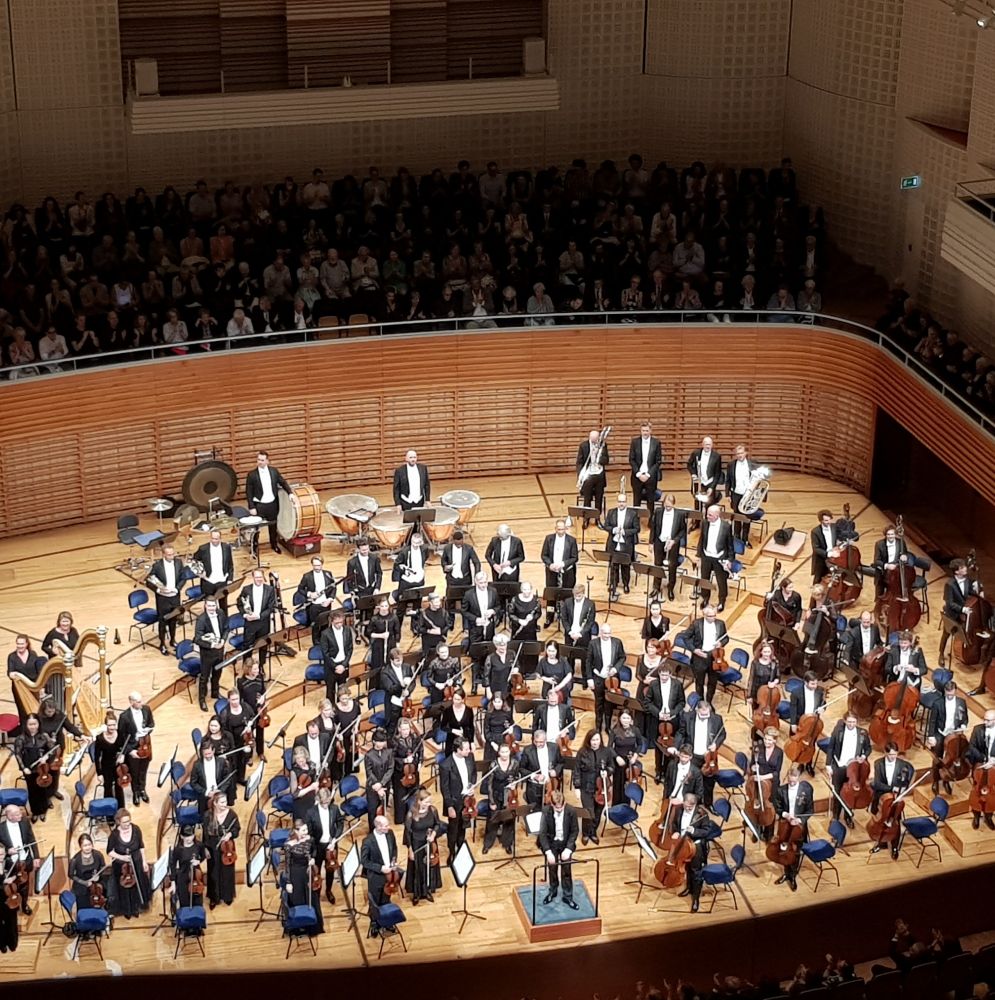 Mäkelä and the orchestra on stage at the end of the concert 