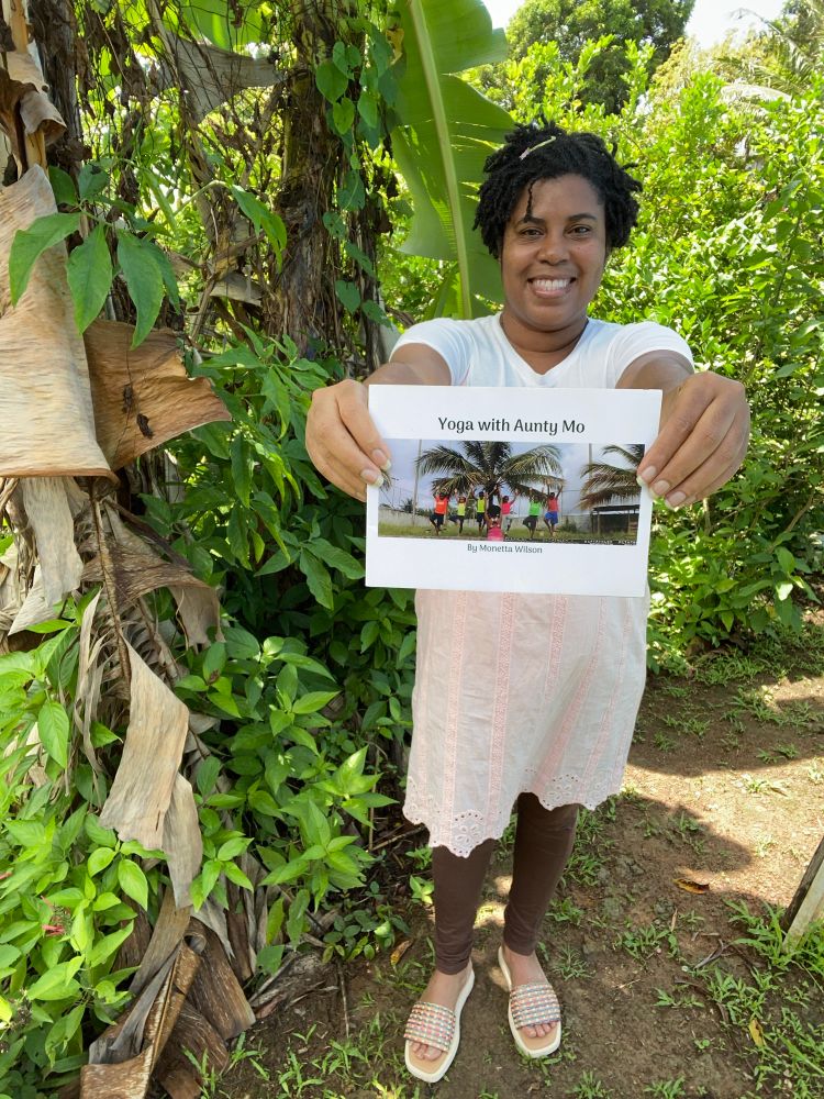 A picture of Mo holding her kids yoga book. 