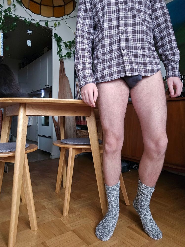 Selfie in a flannel plaid shirt with no pants on and grey woll socks shot from the upper chest down