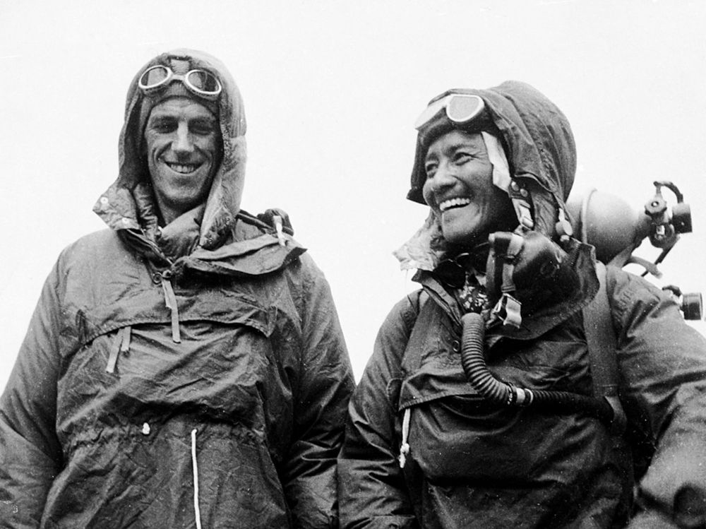 Triumph on the Summit – The First Ascent of Everest (1953)

In this iconic black-and-white photograph taken on May 29, 1953, Sir Edmund Hillary of New Zealand and Tenzing Norgay of Nepal stand atop Mount Everest, having just achieved the first confirmed summit of the world’s highest peak. Both men wear heavy-duty climbing parkas and hoods, their faces radiant with joy and exhaustion. Snow goggles rest atop their foreheads, while coiled ropes, carabiners, and oxygen tanks cling to their chests, marking the technological endurance that supported their success. Despite the harsh conditions and the thinning air of the so-called “death zone” at over 29,000 feet (8,848 meters), their smiles beam with the profound satisfaction of accomplishing what many had deemed impossible.

This moment represents far more than a physical victory. Their ascent came at the tail end of Britain’s extensive Himalayan expeditions, a legacy of geopolitical and scientific ambitions. While Hillary’s name became globally synonymous with Everest, the inclusion and critical contributions of Tenzing Norgay, a Sherpa of humble beginnings, began to shift how the world recognized indigenous expertise in mountaineering. Norgay’s knowledge of the mountain, refined over years of high-altitude portering, was indispensable to the climb’s logistics and safety. Their successful use of closed-circuit oxygen systems—then a cutting-edge adaptation—allowed them to survive and move efficiently through extreme altitudes where atmospheric oxygen drops to just a third of sea-level levels.

The image also captures a pivotal cultural moment: a powerful symbol of international cooperation and technological triumph during a Cold War era that had otherwise been dominated by nationalist competition. Together, Hillary and Norgay stood not just on top of the world, but at the intersection of human spirit, science, and global admiration.