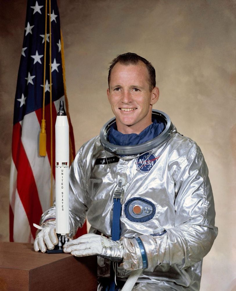 Ed White’s NASA Portrait Before the Gemini IV Mission

This official NASA portrait features astronaut Edward H. White II, the first American to perform a spacewalk, wearing his silvery Gemini-era spacesuit. Taken shortly before the launch of Gemini IV in 1965, the image captures a moment of calm confidence, underscoring White’s vital role in the early years of NASA’s space program. His gloved hands rest on a small scale model of a Titan II rocket—the launch vehicle used for the Gemini missions—and the U.S. flag in the background emphasizes the national pride surrounding America’s push to compete with the Soviet Union during the height of the Space Race. White’s historic extravehicular activity (EVA) on June 3, 1965, marked a pivotal step forward in American spaceflight capabilities. He remained tethered to the spacecraft for 23 minutes, using a hand-held maneuvering unit known as a “zip gun” to control his movements. This iconic achievement helped NASA gain crucial experience with spacewalks, which would later become essential during the Apollo moon landings and in constructing and maintaining the International Space Station. The Gemini program served as a critical bridge between Project Mercury and the ambitious Apollo lunar missions, allowing NASA to test docking techniques, multi-day missions, and human endurance in space. White, a U.S. Air Force officer and test pilot, was selected in NASA’s second group of astronauts in 1962. His training and engineering background made him a standout candidate for EVA operations, and his success on Gemini IV inspired the design of more advanced suits and procedures for future missions. Tragically, Ed White later lost his life during a launch pad fire in the Apollo 1 accident in 1967, becoming one of NASA’s earliest martyrs. This image stands as a tribute to his legacy, capturing the calm courage of a man who made history with one giant leap into the void.