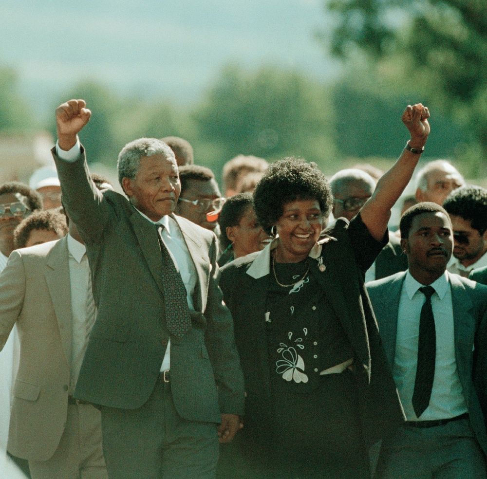 Nelson Mandela’s Historic Walk to Freedom

This powerful photograph captures Nelson Mandela walking hand in hand with his then-wife, Winnie Mandela, on February 11, 1990, just moments after his release from Victor Verster Prison in South Africa. Having spent 27 years in prison, Mandela’s raised fist is a symbol of resilience, resistance, and victory for the anti-apartheid movement. Dressed in a gray suit and white shirt, he steps forward into a future that would soon see him lead South Africa as its first Black president. Winnie Mandela, also raising her fist in solidarity, was a powerful figure in the struggle against apartheid. Surrounding them are supporters and members of the African National Congress (ANC), their faces filled with triumph and emotion. The street is lined with activists, journalists, and citizens eager to witness this historic moment—one that many thought would never come. Mandela’s release followed years of global pressure, economic sanctions, and secret negotiations with the apartheid government. This image signifies the end of an era of institutionalized racial segregation and the beginning of a new chapter in South Africa’s history. It was a moment that resonated worldwide, as Mandela’s freedom symbolized hope not only for South Africa but for oppressed people everywhere. His first words to the public emphasized reconciliation rather than revenge, setting the tone for the nation’s democratic transition. The backdrop of the scene, with the open road ahead, metaphorically represents the long journey toward true freedom and justice. Mandela’s unwavering belief in peace over retribution made this walk more than just a physical act—it was a statement of intent for the future of South Africa. His calm but determined demeanor reflected his readiness to lead a fractured nation toward healing. This photograph is a defining moment in world history, encapsulating the power of perseverance and the triumph of justice.