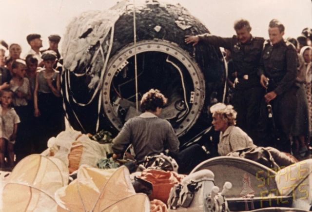Touchdown of Vostok 6 – The Return of the First Woman in Space

This rare, colorized photograph captures the immediate aftermath of the landing of the Vostok 6 capsule, which carried Valentina Tereshkova safely back to Earth on June 19, 1963. Surrounded by curious villagers and uniformed military personnel, the spherical descent module sits scorched and battered, a testament to its fiery re-entry into Earth’s atmosphere. Parachutes and equipment are strewn around the scene, and a small group, including Tereshkova herself, appears to be recovering gear and inspecting the landing site in a moment that blends both triumph and fatigue.

After orbiting Earth 48 times over nearly three days in space, Tereshkova made a manual re-entry and ejected from the capsule shortly before touchdown—parachuting to the ground near a rural area in the Altai region of Siberia. This was standard procedure for the Vostok program, whose capsules were not designed to land with the cosmonaut still inside. The landing took locals by surprise. According to accounts, Tereshkova’s sudden appearance in a flight suit and helmet alarmed residents until she calmly explained she had come from space. She was offered milk and bread by the villagers, underscoring the surreal intersection between high technology and rural life.

This image is more than a snapshot of a landing—it is a visual testament to the full arc of a mission that shattered barriers. Tereshkova’s return to Earth completed the journey of the first woman in space, proving that gender posed no biological obstacle to space travel. The Soviet Union used the event to trumpet its progressiveness and scientific superiority on the world stage. Yet for all the geopolitical significance, this image grounds the story in something human: a young woman emerging from a metal sphere in a field, met by ordinary people whose lives would never reach orbit, but who bore witness to someone who had.