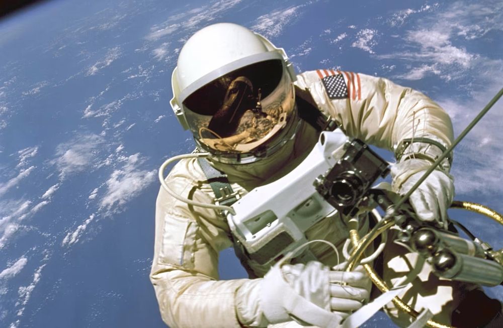 Ed White’s Historic Spacewalk Above Earth – A Defining Moment in Human Exploration

In this breathtaking photograph, astronaut Ed White floats freely above the Earth during his historic extravehicular activity (EVA) on June 3, 1965, becoming the first American to perform a spacewalk. Captured during NASA’s Gemini IV mission, the image shows White tethered to the spacecraft by an umbilical cord and maneuvering with a hand-held gas-powered “zip gun” called the Hand-Held Maneuvering Unit. His visor reflects the spacecraft and fellow astronaut James McDivitt, who piloted Gemini IV from within. The vibrant blue arc of Earth curves below, dotted with clouds, accentuating the enormity of space and the fragility of the human form against the cosmos. Lasting 23 minutes, White’s EVA was a pivotal step in American spaceflight, demonstrating not only the physical possibility of operating outside a spacecraft but also the psychological readiness of astronauts to handle the isolation and freedom of open space. The image encapsulates a sense of awe, courage, and scientific achievement that defined the space race era. Though the Soviet Union had completed the world’s first spacewalk just months earlier, White’s EVA marked a leap in NASA’s capabilities and offered valuable data that would shape future missions, including Apollo’s lunar EVAs and decades of work aboard the International Space Station. The suit he wears was a modified Gemini G4C pressure suit designed to provide mobility, temperature regulation, and protection from micrometeoroids—critical innovations for future spacewalks. This moment above the Earth was so moving that White resisted returning to the capsule, famously remarking, “It’s the saddest moment of my life.” The image remains one of the most iconic in the history of space exploration, symbolizing not only a triumph of technology but a profound moment in humanity’s quest to explore beyond its home planet.