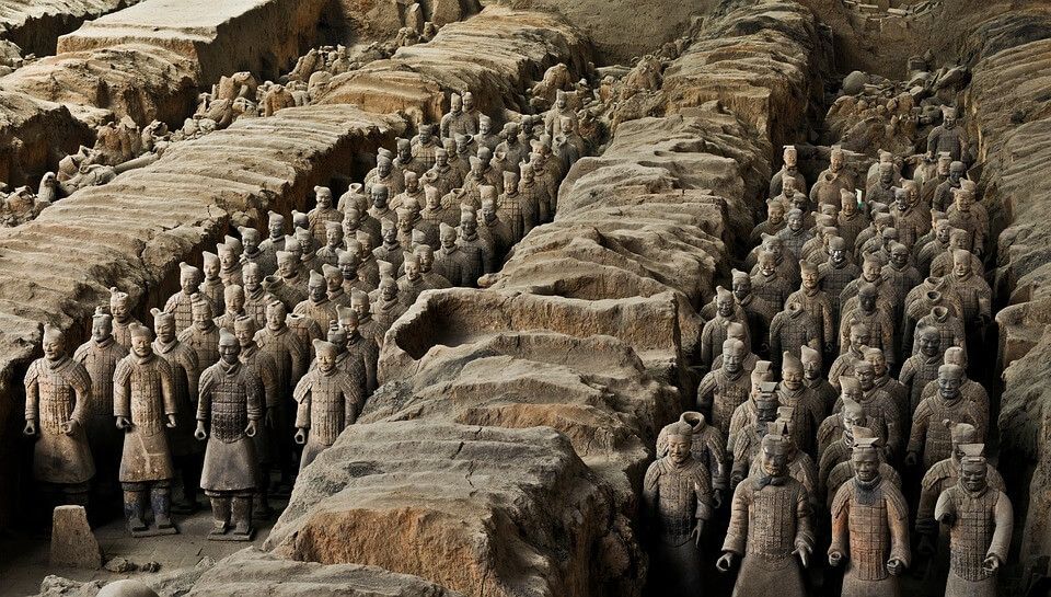 Terracotta Army in Excavation Pit – Rows of Eternal Guardians

This image captures a breathtaking view inside one of the excavation pits at the Terracotta Army archaeological site near Xi’an, China. Stretching back into the shadows, rank upon rank of life-sized clay soldiers stand in precise formation, flanked by earthen walls that once concealed them for over 2,000 years. The figures—each uniquely crafted with distinct hairstyles, facial expressions, armor, and posture—represent a fully mobilized imperial force frozen in time, guarding the tomb of Qin Shi Huang, the first emperor of unified China. The orderly lines reflect both the military discipline of the Qin dynasty and the logistical mastery required to construct such a vast funerary complex. Buried in 210 BCE, these warriors were meant to serve the emperor in the afterlife, a testament to his ambition and belief in eternal rule. The image highlights not just the artistry of the ancient craftsmen—who molded and painted each figure by hand—but also the architectural complexity of the site, which includes underground stables, command posts, and chariot divisions. Though faded with time, the figures’ silent expressions echo a powerful cultural truth: Qin Shi Huang intended to carry the full weight of his empire beyond death. When local farmers accidentally unearthed fragments in 1974, they opened a window into a world of ritual, hierarchy, and obsessive control. This moment transformed our understanding of early Chinese statecraft, illuminating a period where power, myth, and mortality converged underground. As excavations continue, many mysteries remain—how many figures are still buried, what secrets lie in the unopened central tomb, and how the army’s original colors might have once dazzled viewers. This photo is not just a document of clay statues—it is a moment suspended between past and present, where ancient China speaks in the language of stone.