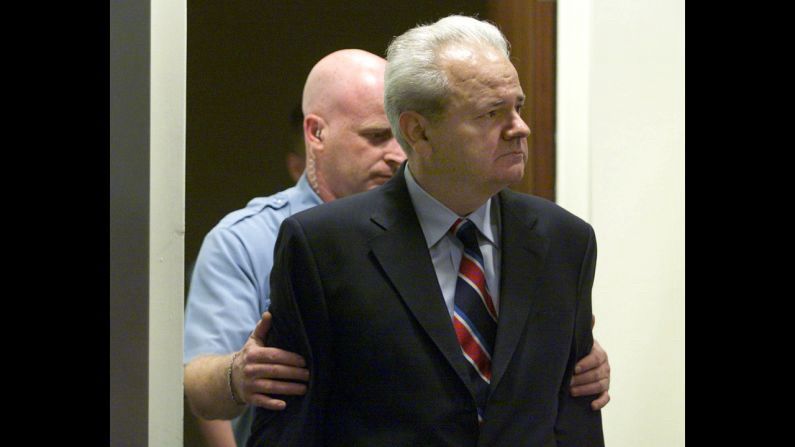 The Arrest of Slobodan Milošević – The Fall of a Former Strongman

This historic black-and-white image captures Slobodan Milošević, the former President of Serbia and the Federal Republic of Yugoslavia, being escorted by a uniformed guard during his arrest and extradition to The Hague in 2001. Clad in a dark suit and striped tie, Milošević’s downcast, stoic expression belies the gravity of the moment—a symbol of a former head of state brought under the jurisdiction of international law. Behind him, the guard’s firm grip underscores the shift from unchecked political power to judicial accountability. This moment directly connects to the landmark event of May 27, 1999, when the International Criminal Tribunal for the former Yugoslavia (ICTY) indicted Milošević for crimes against humanity, including murder, deportation, and persecution during the Kosovo conflict. It was the first time in history a sitting head of state had been charged with war crimes by an international court. The indictment marked a turning point for global justice, signaling that sovereign immunity would no longer shield leaders from prosecution for atrocities. Crucially, the ICTY’s ability to gather digital evidence, including intercepted communications, satellite imagery, and victim testimonies shared across borders, marked a new era of technology-driven accountability. The photo reflects both the fragility of power and the resilience of international legal frameworks that strive to uphold human rights in the wake of violent nationalism and war crimes. The case set precedents used later in tribunals for Rwanda, Sierra Leone, and even influenced the formation of the International Criminal Court. This image freezes the moment when justice caught up to one of the Balkans’ most controversial figures, reshaping post-Cold War perceptions of international law’s reach.