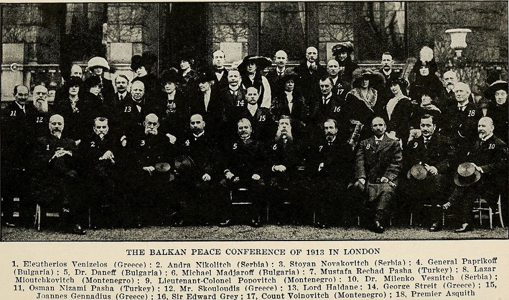 Delegates of the 1913 Balkan Peace Conference in London

This historic photograph captures the assembled delegates of the Balkan Peace Conference of 1913 in London, convened to negotiate and finalize the Treaty of London following the end of the First Balkan War. Seated and standing are statesmen, diplomats, military officers, and political leaders from the countries involved in the conflict—primarily the members of the Balkan League (Greece, Serbia, Montenegro, and Bulgaria) and representatives of the fading Ottoman Empire. The peace talks, hosted in the prestigious St. James’s Palace and overseen by major European powers, were aimed at redrawing borders in southeastern Europe after the collapse of Ottoman military resistance in the Balkans.

In the image, the numbered key below the photograph identifies many of the key figures. Among them is Eleftherios Venizelos of Greece (1), a pivotal architect of Greek military and diplomatic strategy, seated beside Serbian, Bulgarian, Montenegrin, and Turkish delegates. Sir Edward Grey (16), the British Foreign Secretary, played a crucial role as a mediator during the negotiations. The diversity of attire—from military uniforms to formal diplomatic wear—underscores the blend of martial and political influence shaping the post-war landscape.

Though the image conveys a moment of unity, tensions simmered just beneath the surface. Bulgaria, dissatisfied with the division of Macedonia, would soon wage war against its former allies, initiating the Second Balkan War less than two months after this photograph was taken.

This image is more than a diplomatic portrait; it is a snapshot of a crucial moment when old empires crumbled, new borders emerged, and Europe edged closer to a continent-wide conflagration. It illustrates how diplomacy, even when conducted in ornate chambers with handshakes and signatures, can be both the end of one war and the prelude to another.