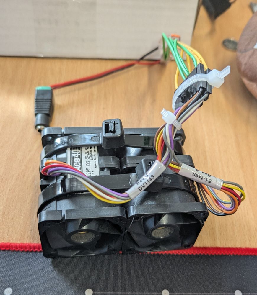 A pair of server fans cable-tied together and manually wired into a DC barrel socket