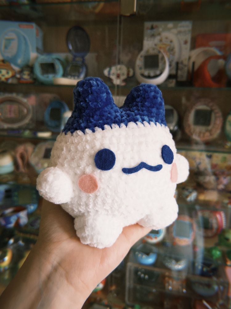 A crochet amigurumi made in super soft and squishy chenille of the tamagotchi character Mimitchi!