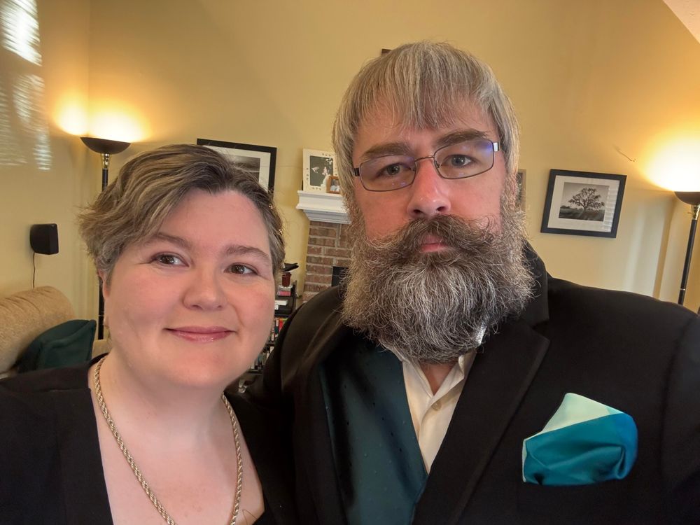 picture of a man and woman in formal attire.  framing is from the chest up.  I'm in a tux with green vest.  she is in a black dress with a cover.