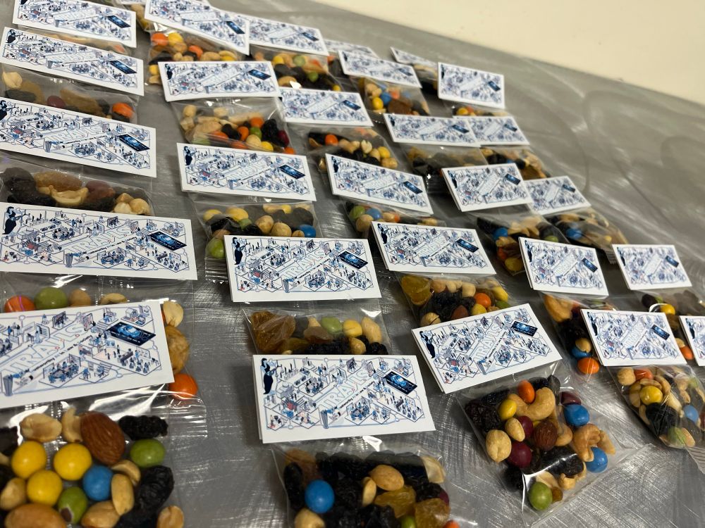 table with a bunch of miniature packets of trail mix with trails branding