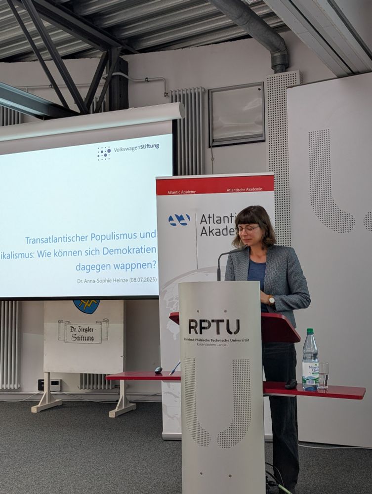 Foto der Referentin, hinter dem Rednerpult stehend vor der Power Point Präsentation.