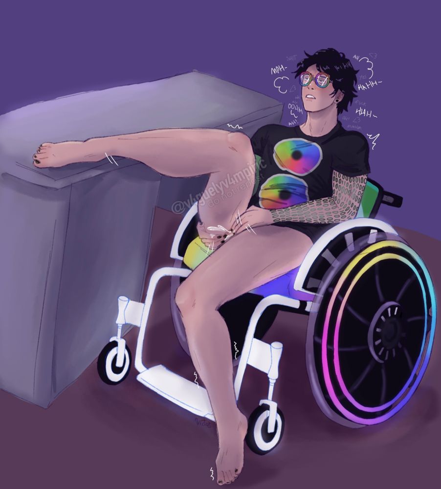 Mac Date Everything pleasuring themself, leaning back in their wheelchair with one leg on the desk, naked from the waist down.