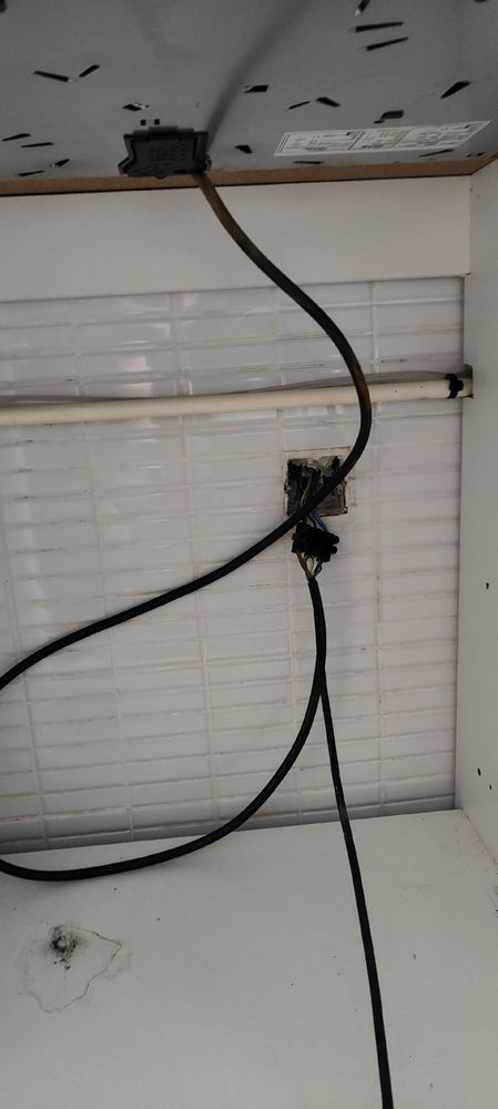 Un agujero en la pared detrás del horno para un enchufe, el cable de la vitro y el del horno en una misma caja de empalmes