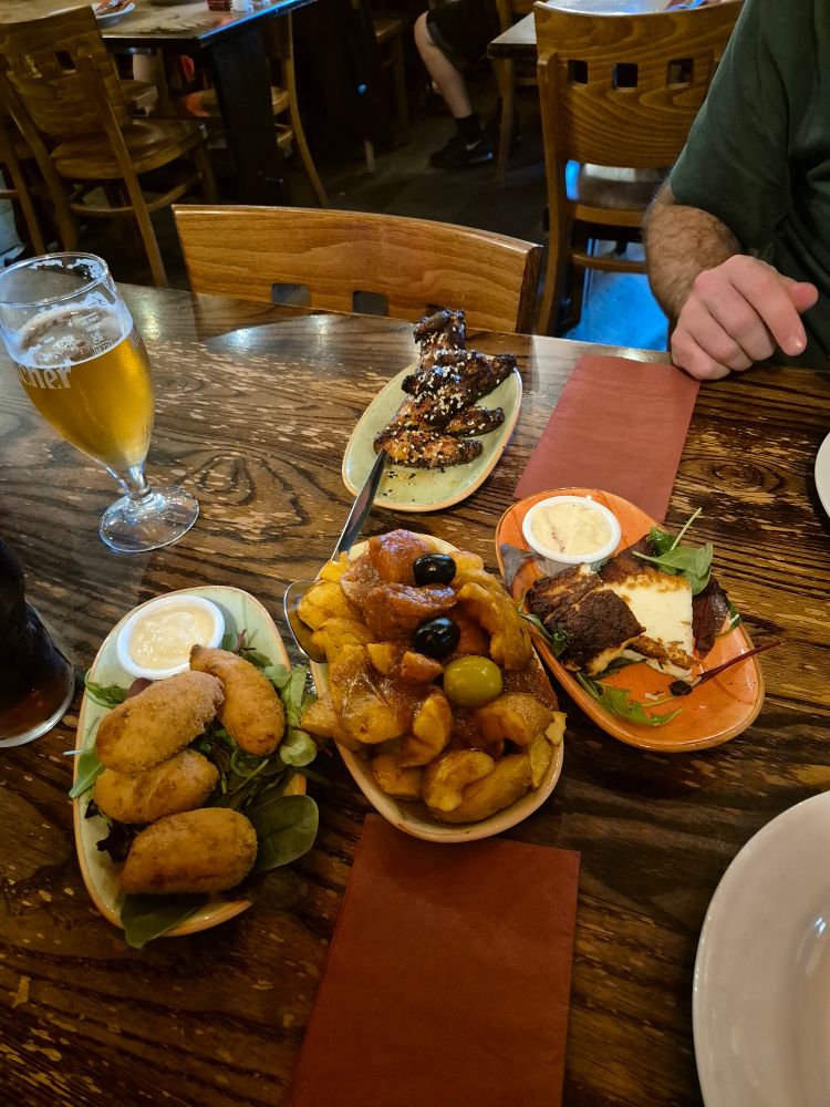 A selection of tapas. Ham and cheese croquettes, patatas bravas, halloumi and hot honey chicken wings