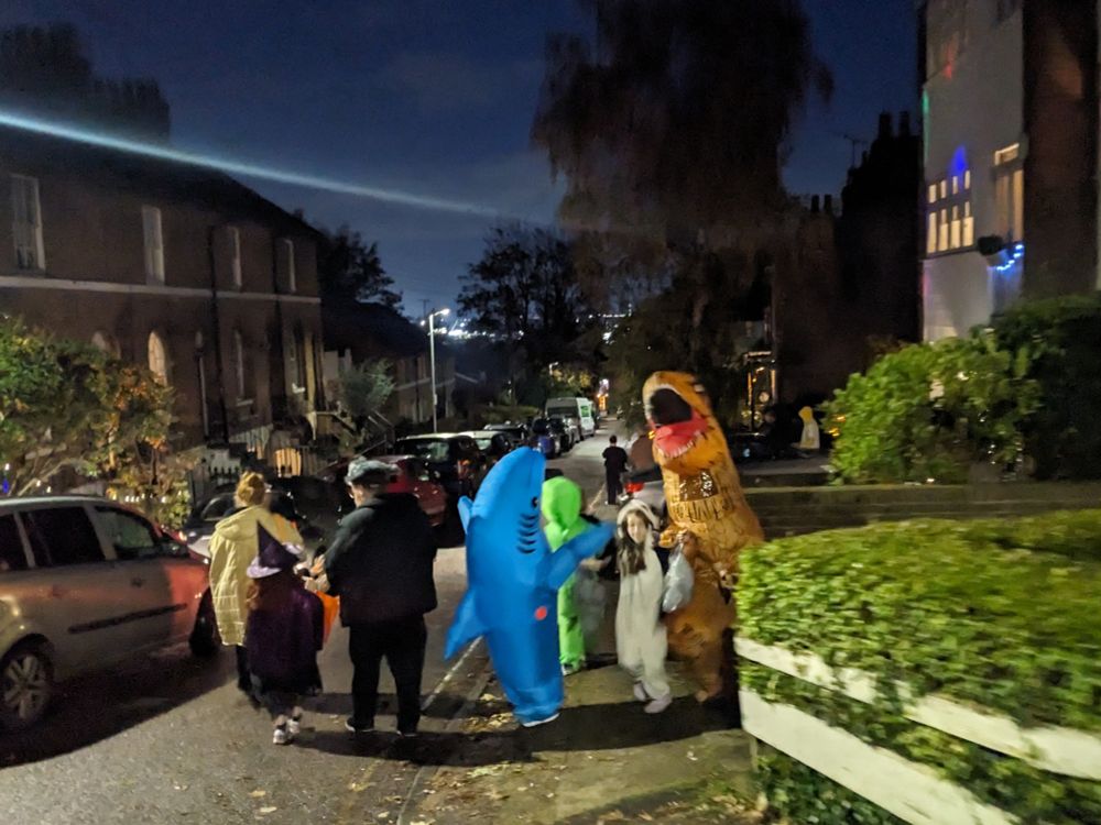 Shark, T-rex, alien, panda and witch on a dark English street 