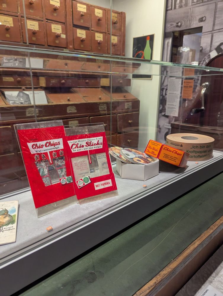 In einer Vitrine sind Urpackungen der ersten Chio-Chips abgebildet.