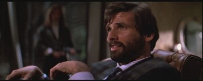 Photo of a bearded businessman, clearly pleased with himself and thinking himself smarter than he is— which is not smart. In this photo he believes he is negotiating the release of himself and his coworkers who are being held hostage by terrorists. He has that face you just wanna hit. I will not disclose what actually happens to him in case you have not seen Die hard, the classic Christmas movie. 