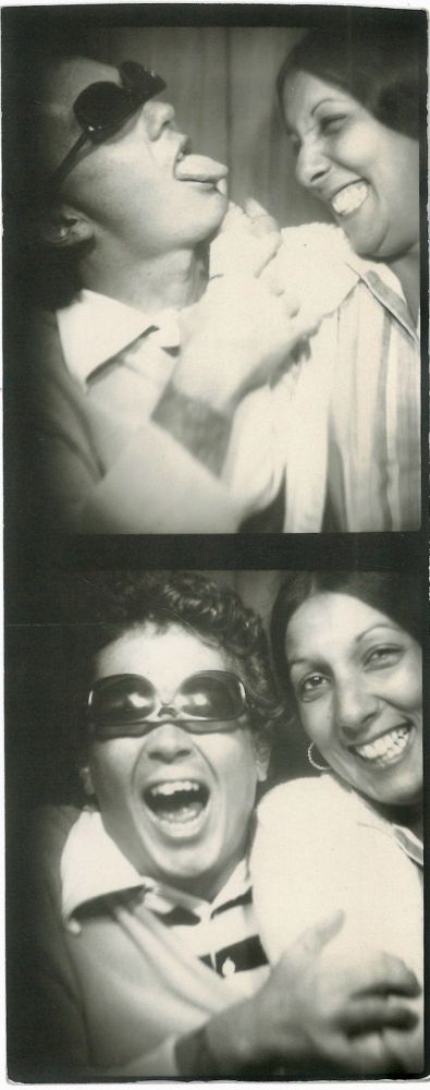 A strip of two photo booth photos of Hardy and Passalacqua. Hardy is wearing his sunglasses upside down and making funny faces while Passalacqua is laughing.