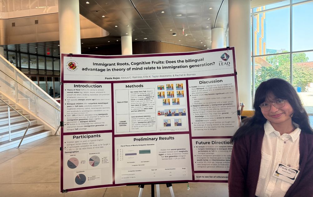 Photo of Paola (right) in front of her poster "Immigrant Roots, Cognitive Fruits: Does the bilingual advantage in theory of mind relate to immigration generation?" 