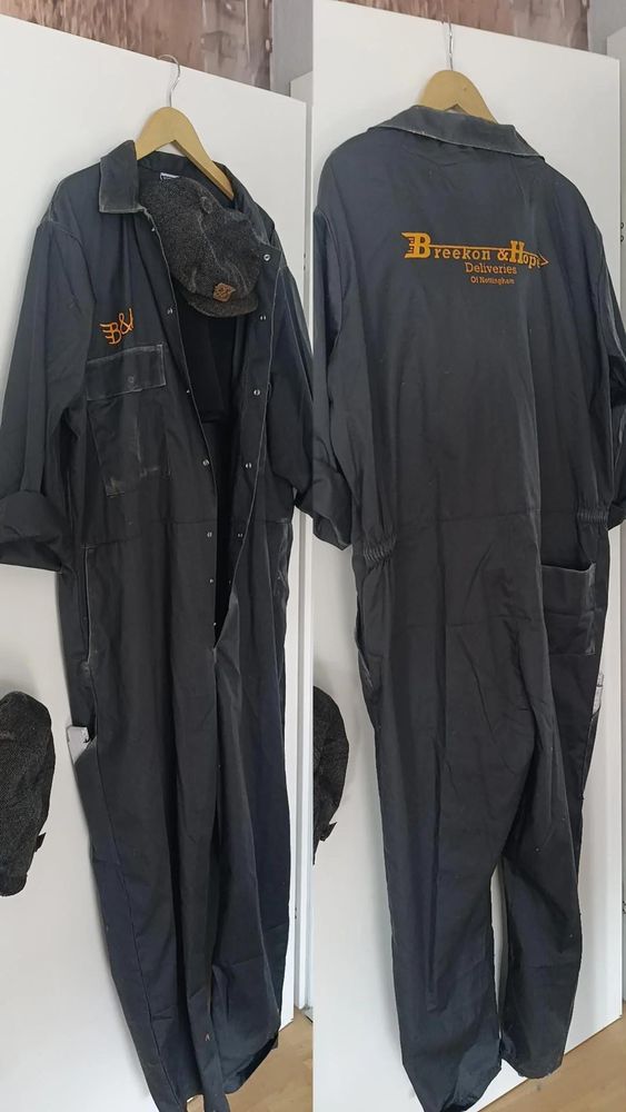 Ein Bild mit zwei Fotos, links ist ein grauer Arbeitsoverall von vorne, rechts gleicher Anzug von hinten fotografiert, damit man das orange-gelbe Logo "Breekon & Hope, Deliveries of Nottingham" sieht.