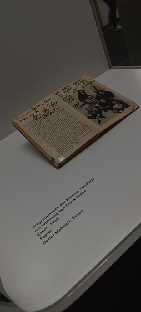 Ein aufgeschlagenes Buch in einer Vitrine, dass von Frank Zappa unterschrieben wurde.