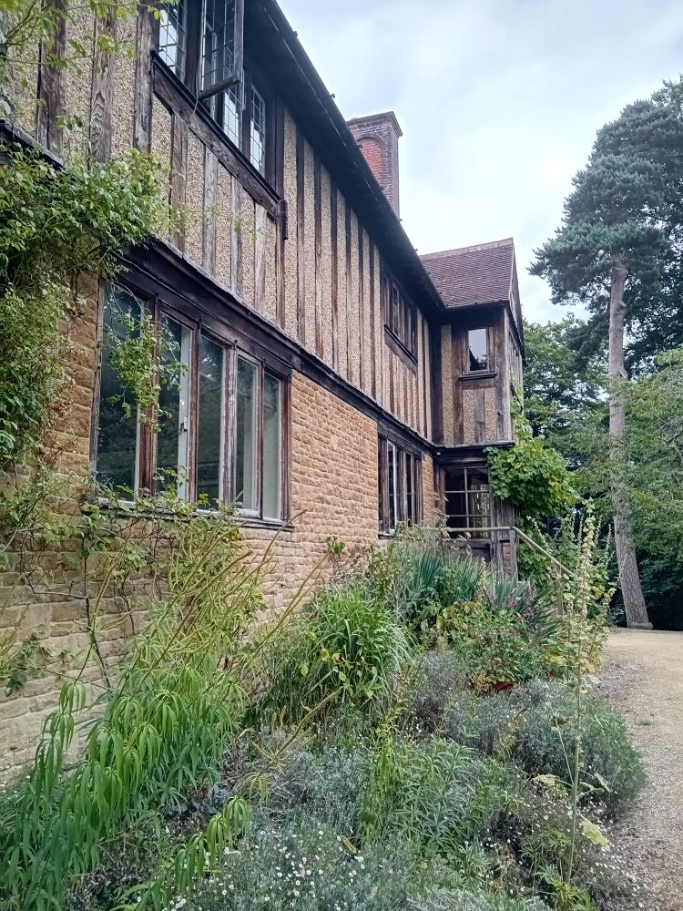 Side view of the front of the house showing a bay window and flower bed.