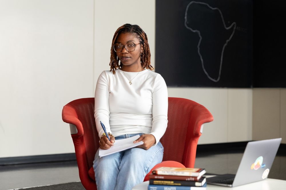 Maame sitting in an office chair with a laptop in front of her