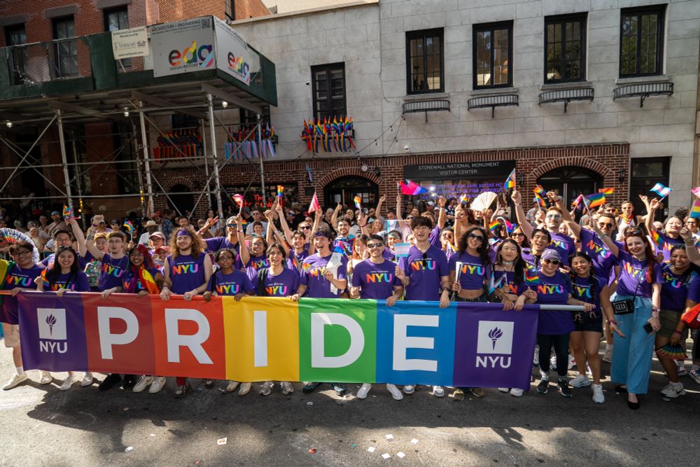 The group of NYU marchers behind a pride banner in front of the Stonewall Inn