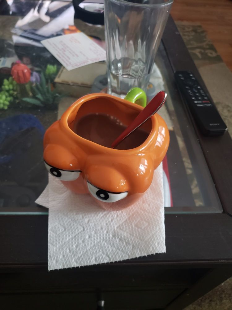 A dougdoug mug mug (a bellpepper shapped mug with cartoon eyes) with hot coco in it.