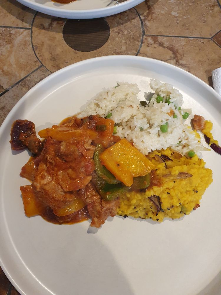 Large white plate with portions of chicken jalfrezi, tarka daal and basmati rice.