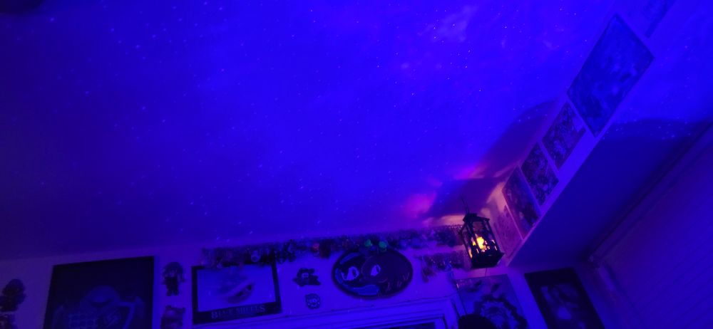 The ceiling is purple and dotted with tiny lights that resemble stars, like a galaxy. In the corner hangs a lantern emanating orange light.