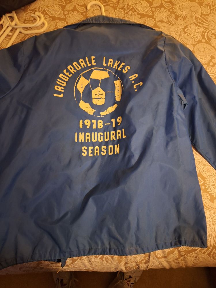 Blue windbreaker that had a has a screen printed soccer with lettering that reads 