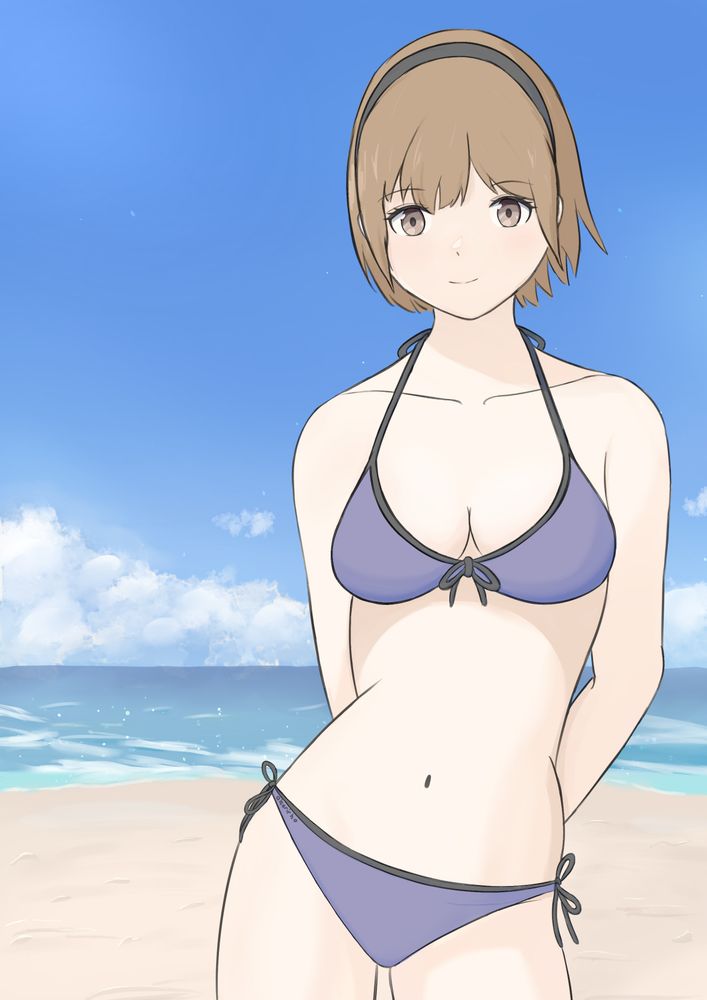 Young woman wearing a bikini style swimsuit on a sunny day at the beach. She’s looking towards the viewer smiling with her arms behind her back and hips to the side. She has short brown hair proofed up in the back by a headband. Her Swimsuit is dark purple with black accents on the ties matching her headband.
