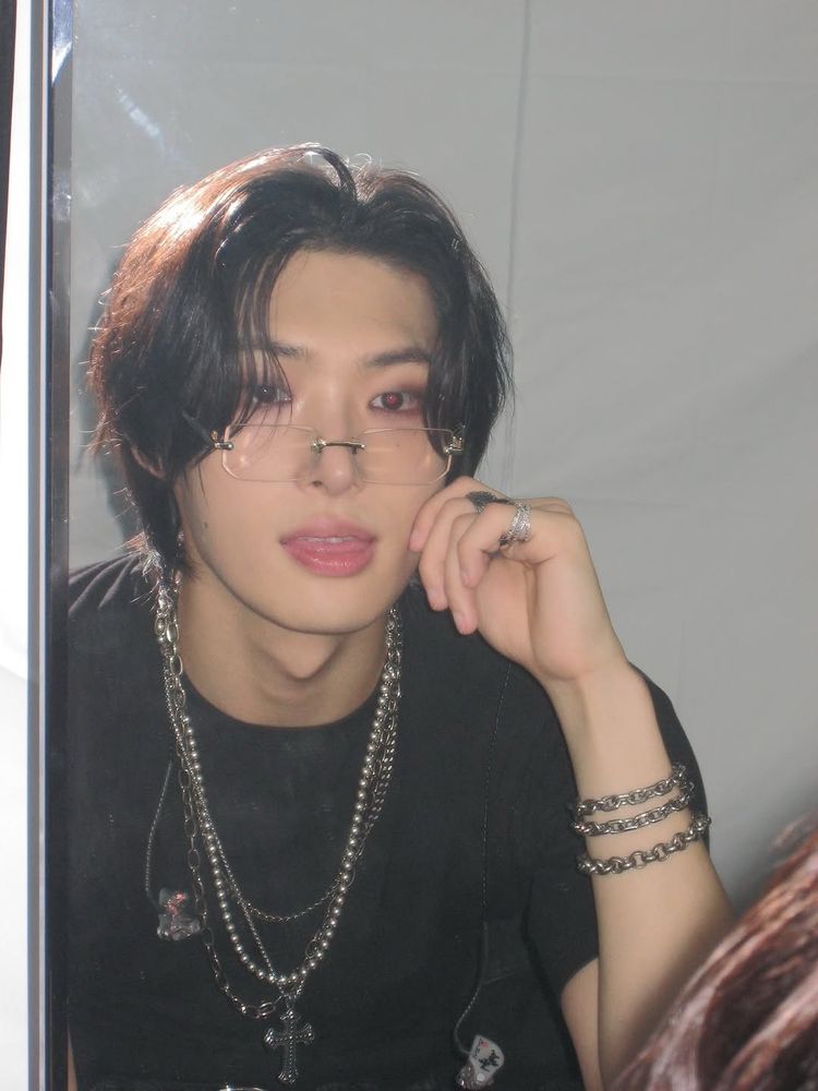 Mingi looking at himself in the mirror, tongue slightly poking out, pinching his own cheek.