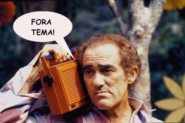 Foto de Renato Aragão segurando um rádio na altura da orelha, com um balão de fala escrito FORA TEMA! ao lado.