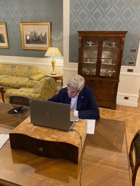 John Kerry using an antique desk drawer as a laptop stand