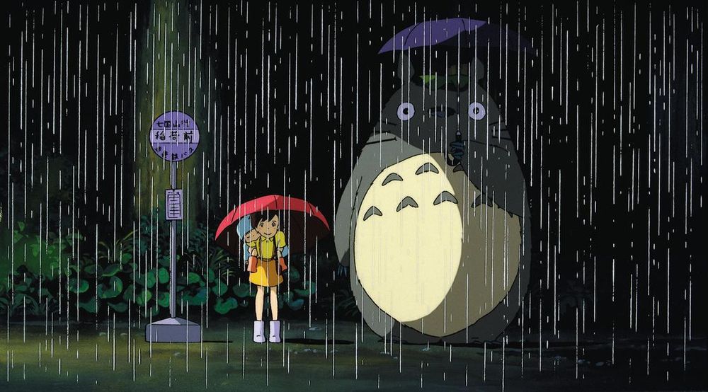 Totoro standing in the rain waiting for the bus next to the kids.