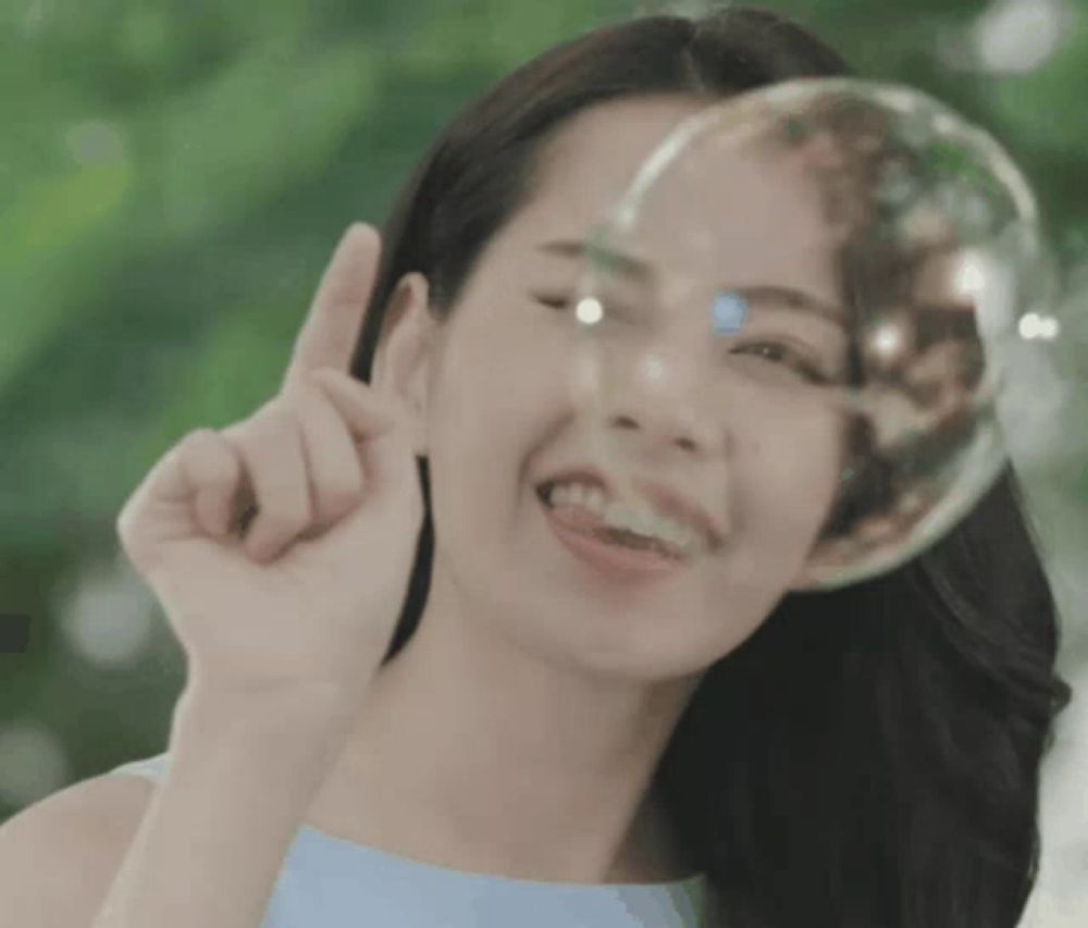 a woman with a soap bubble behind her face