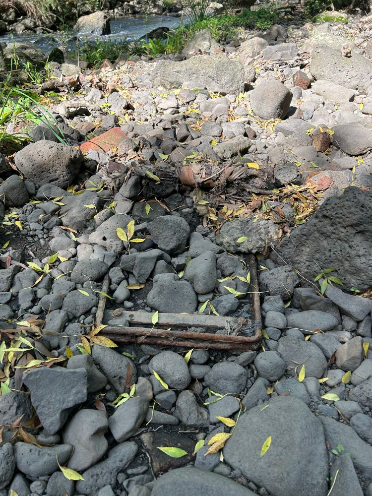 A supermarket trolley mostly concealed by an extensive collection of Riverstone's this shopping trolley has been in this river for a very long time and the very limited amount of it which is exposed is rusted and I have likened it to the state of America. They forgot. Forgot that not everything can be bought. They forgot that not everything *should* be bought and now they are this supermarket trolley rusting in a creek.
