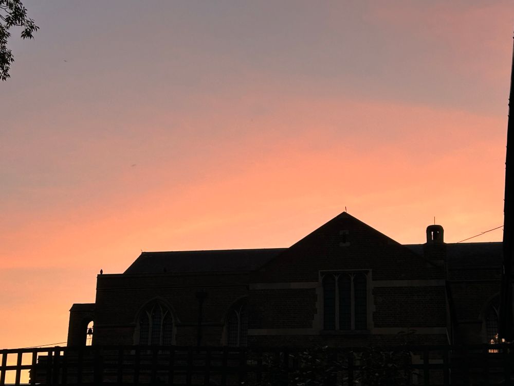 Pink and orange sky at sunset over our church