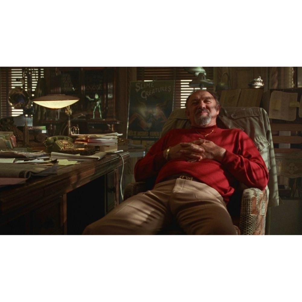 Film still of Gene Hackman as Harry Zimm in Get Shorty. Sitting in his dimly lit office. 