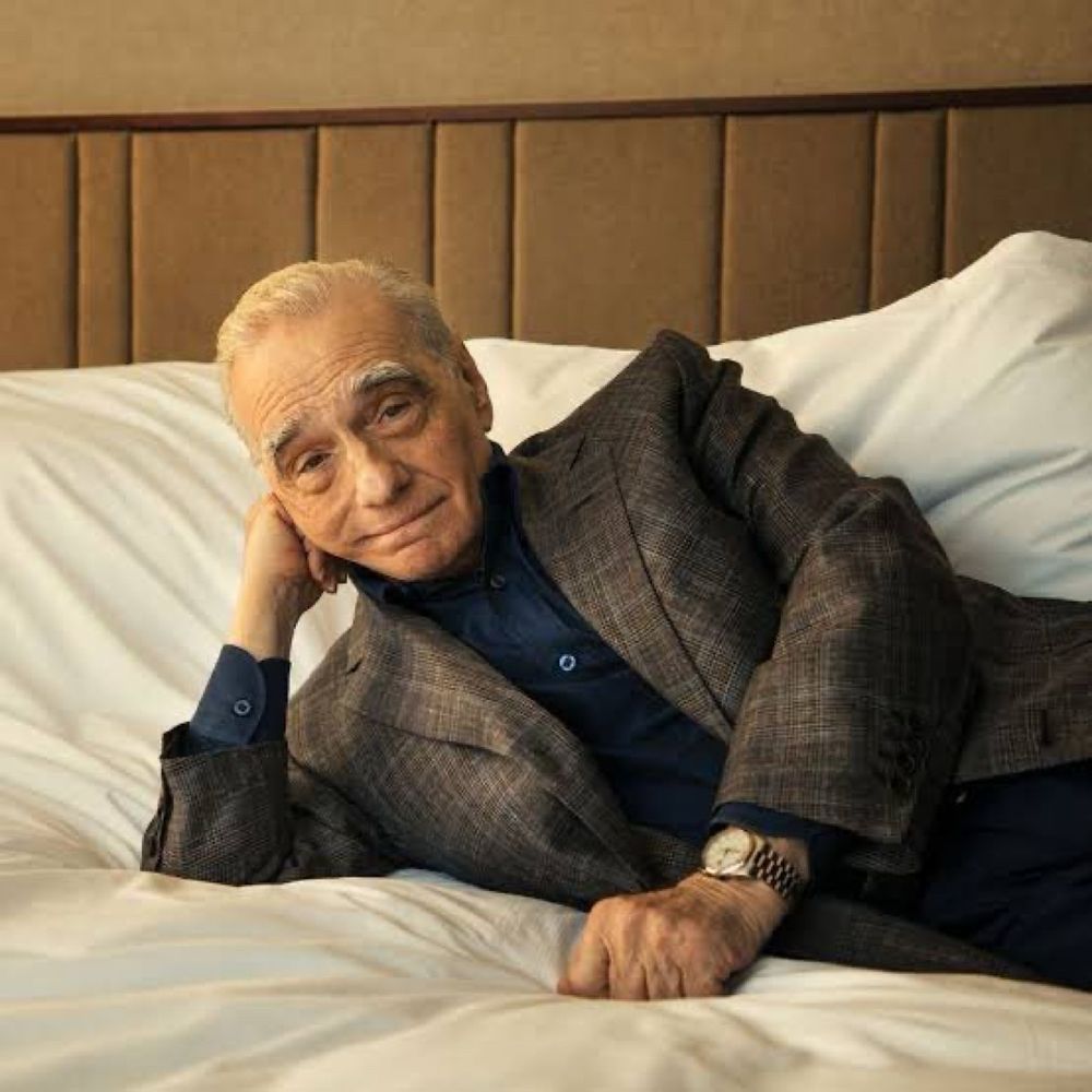martin scorsese laying on a bed, head propped up with his arm and smirking lol 