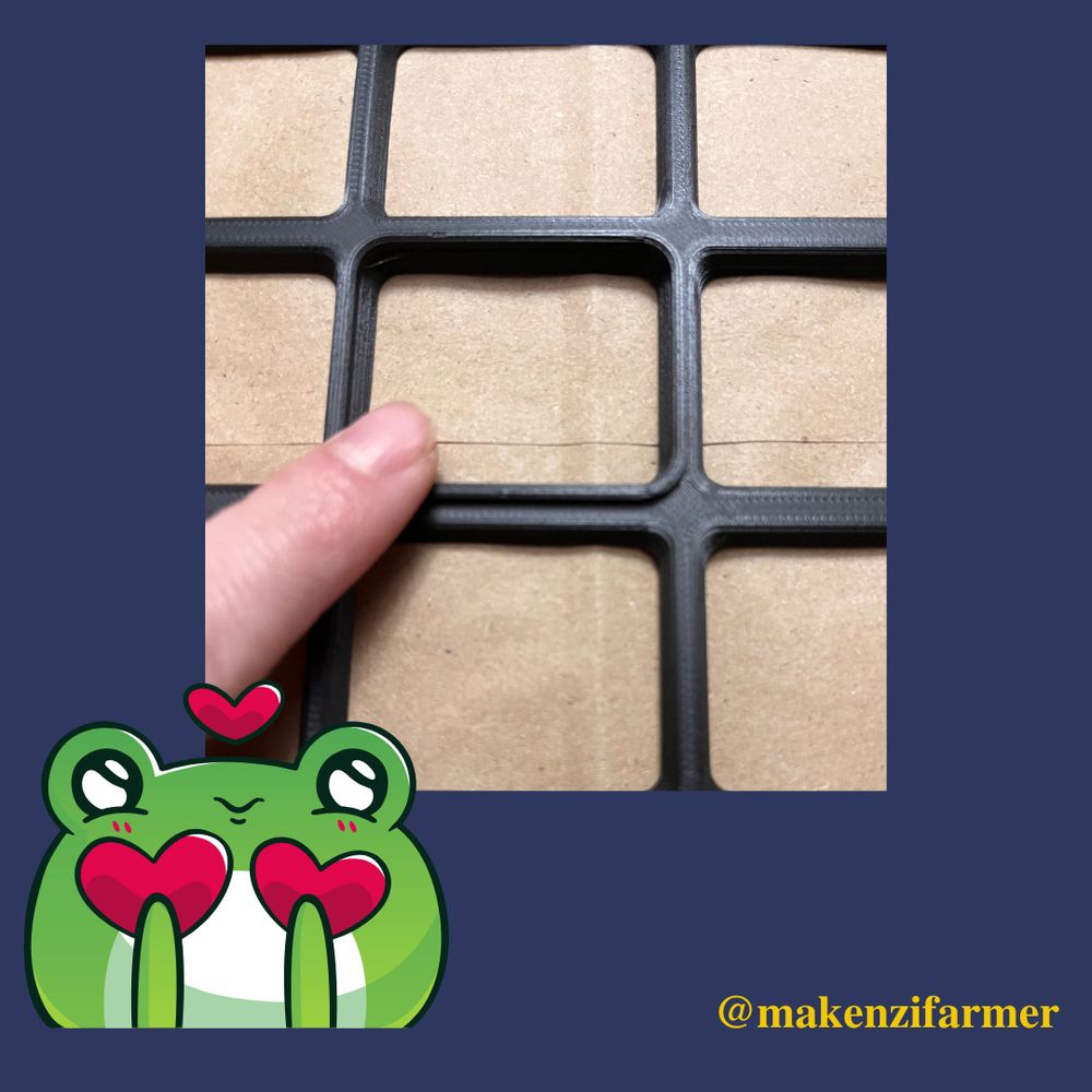 A close up of the black plastic keyguard and a finger pointing to the raised edge of the cell. The post’s background is blue with a cartoon frog and hearts in the bottom right. “@makenzifarmer” is displayed in the bottom right corner. 