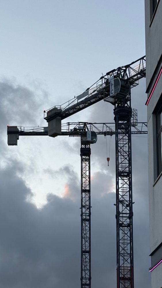 Construction cranes on a moody night