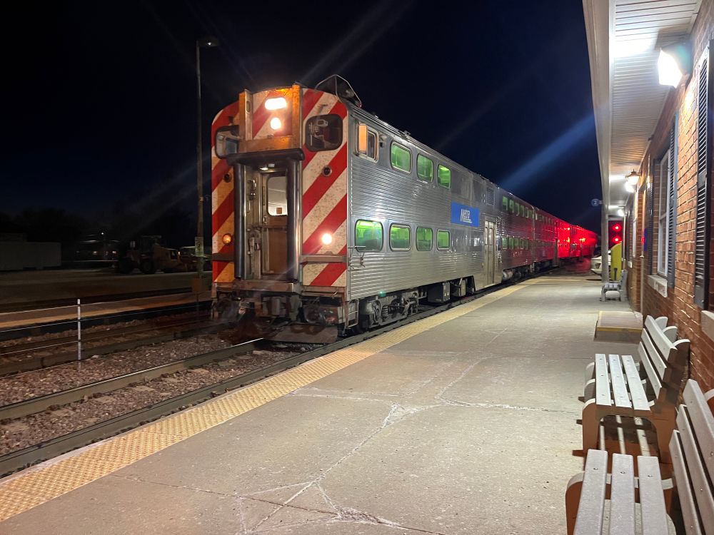 A Metra train arriving at night.