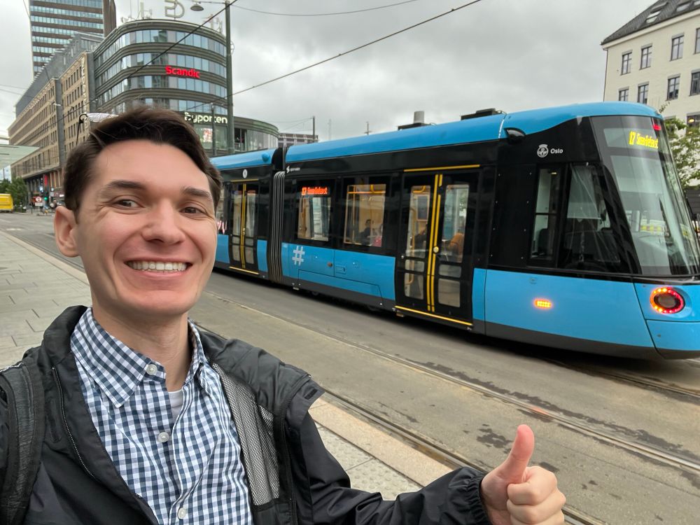 Me having finished the tram network, commemorative "thumbs-up" in front of a tram in Oslo.