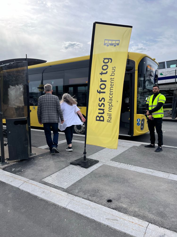 A yellow flag that says Buss for tog (Rail Replacement Bus) in front of a bus