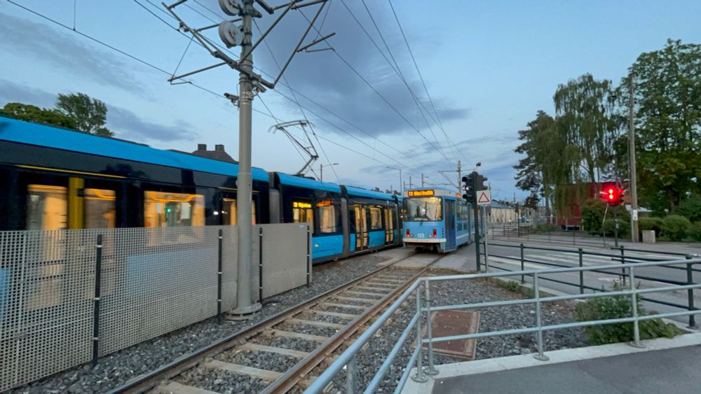 An older tram passing a newer tram